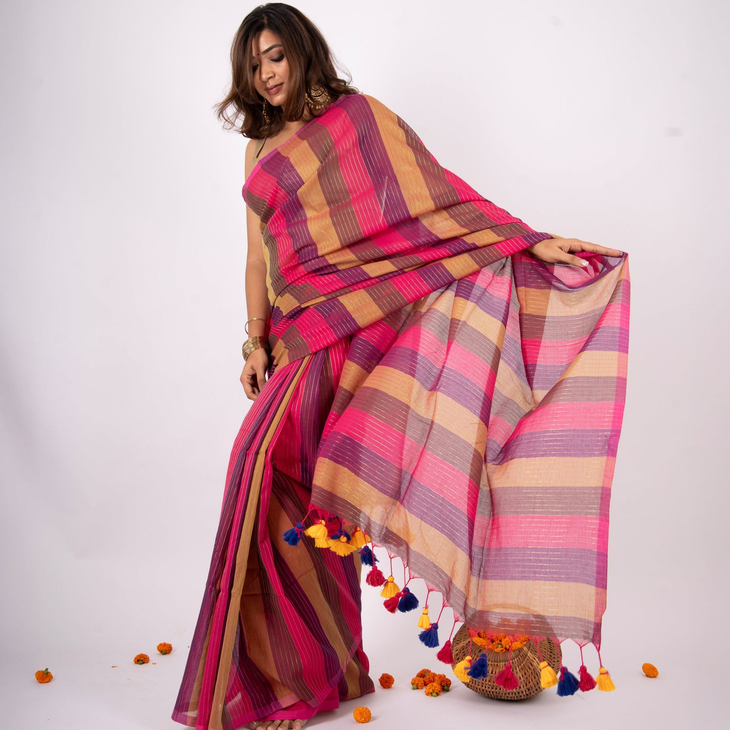 Woman wearing a colorful striped saree with a white background