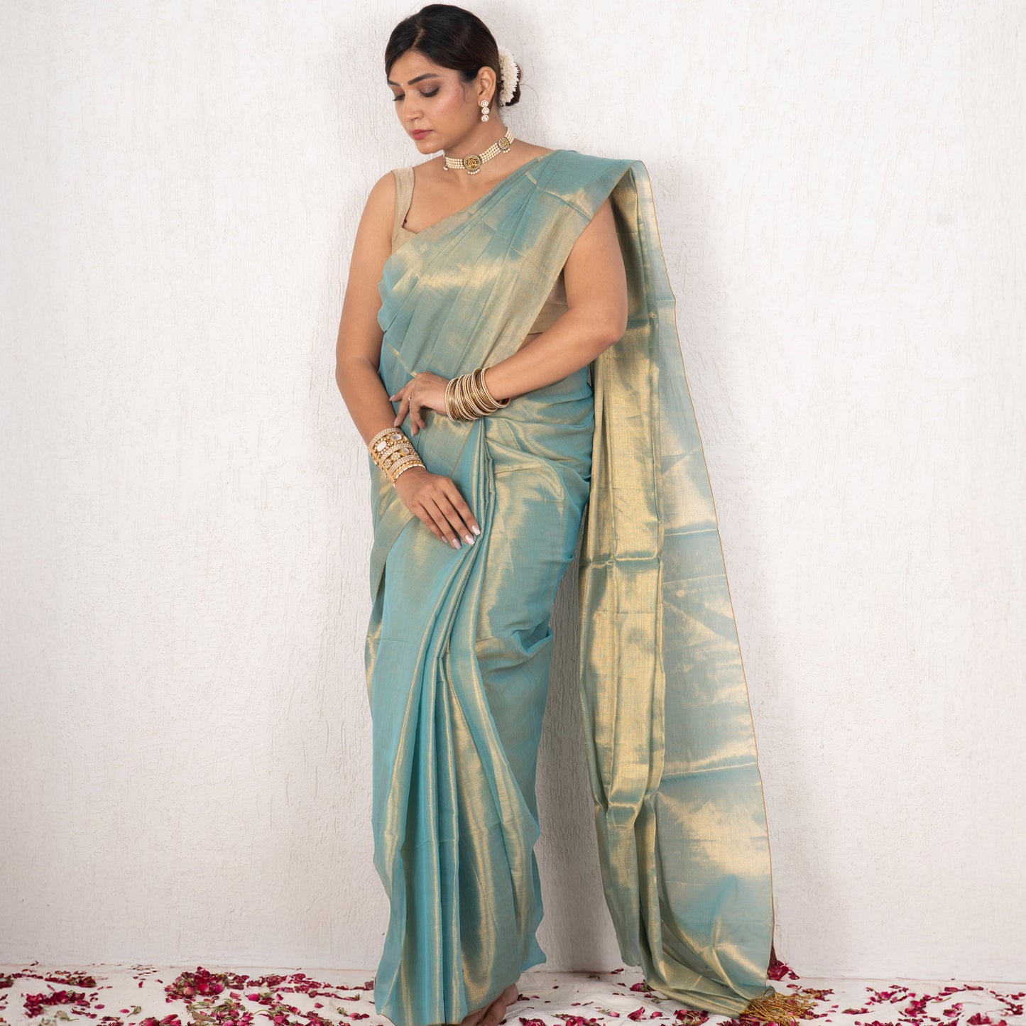 Woman wearing a light blue saree with a white background