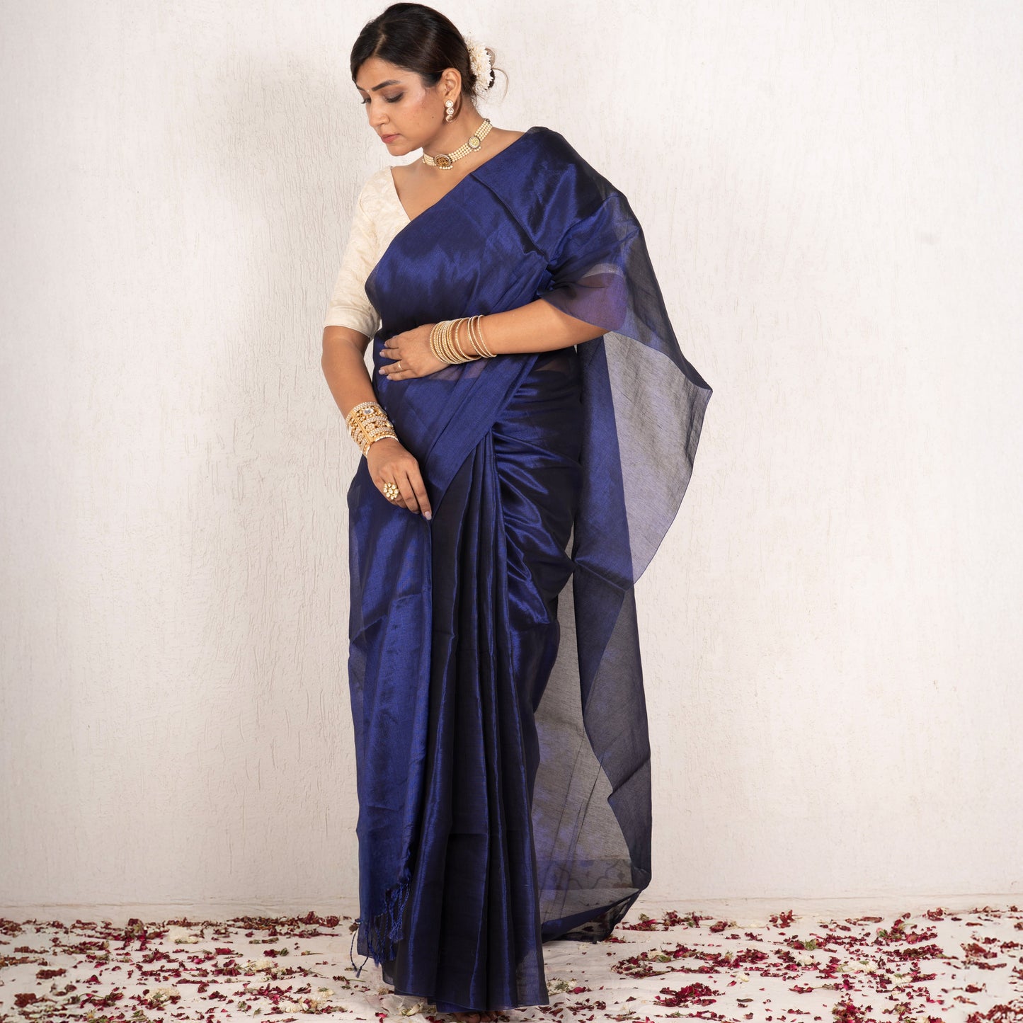 Woman wearing a blue saree with a white background