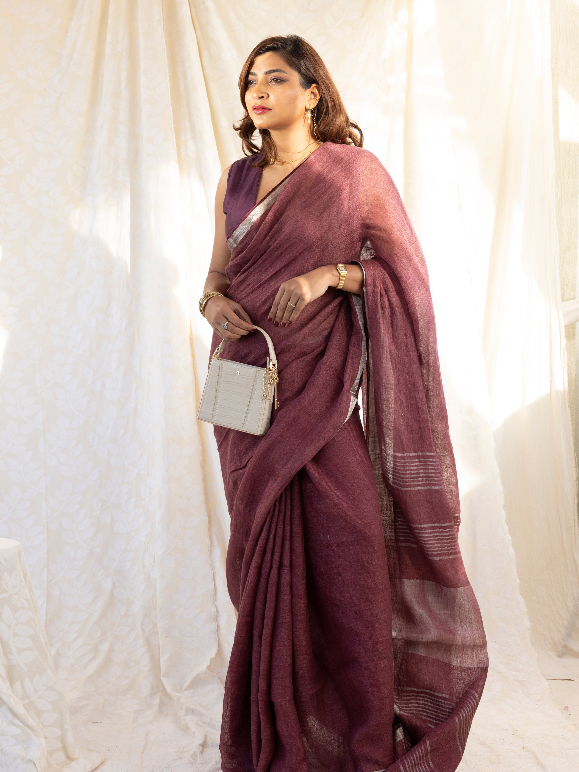 Woman wearing a maroon saree with a white background