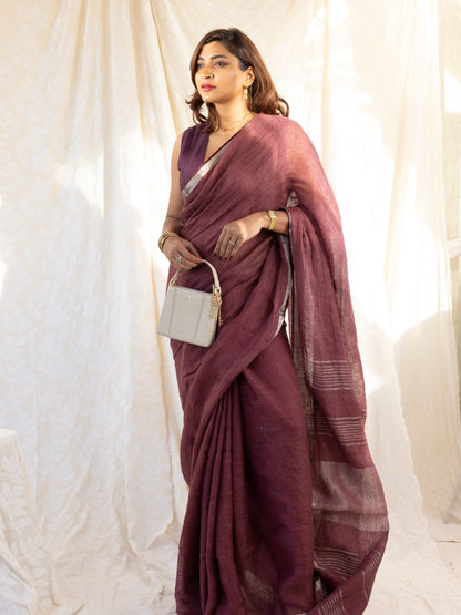 Woman wearing a maroon saree with a white background
