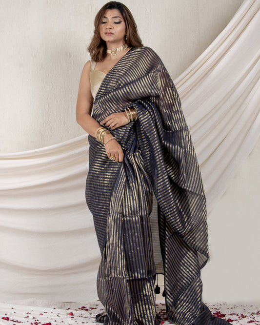 Woman wearing a traditional saree with a white background and floral decorations.