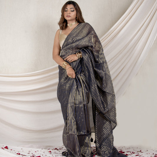 Woman wearing a traditional saree with a white background and floral decorations.
