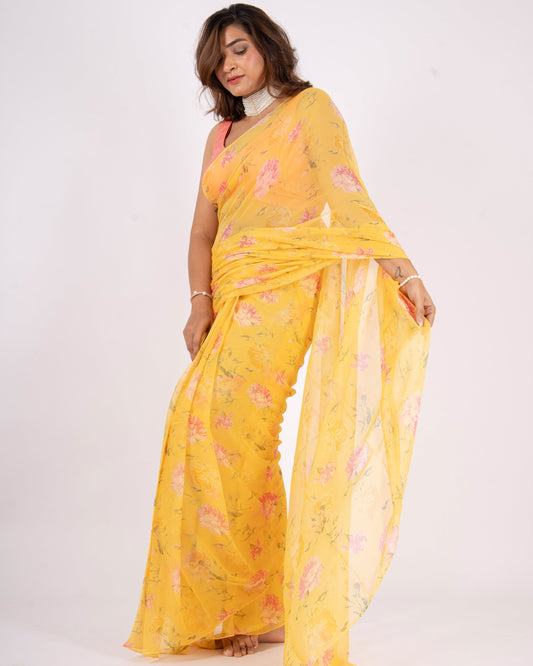 Woman wearing a yellow saree with a floral pattern on a white background
