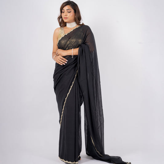 Woman wearing a black saree with a white blouse on a white background