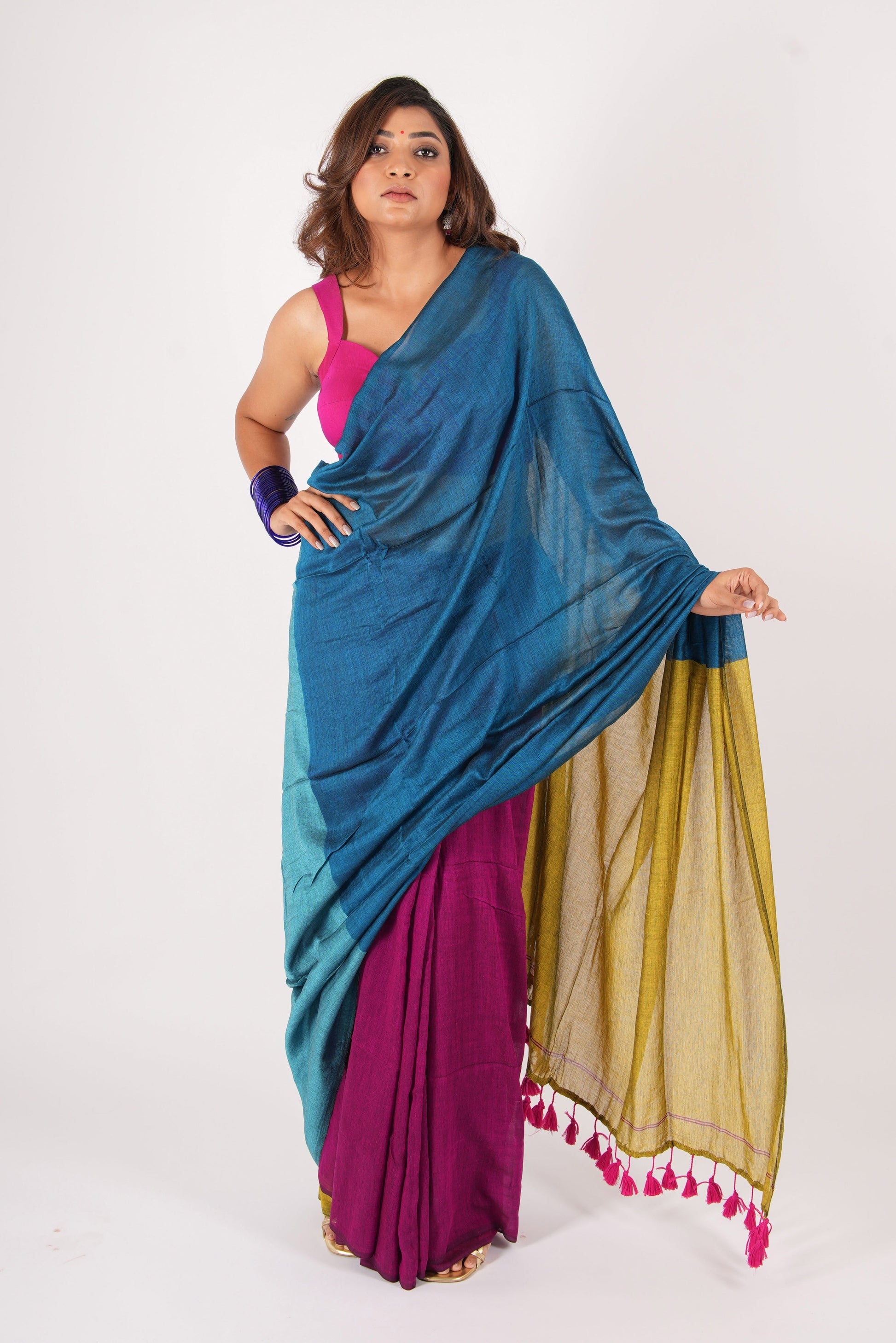 Woman wearing a blue, pink, and beige saree on a white background