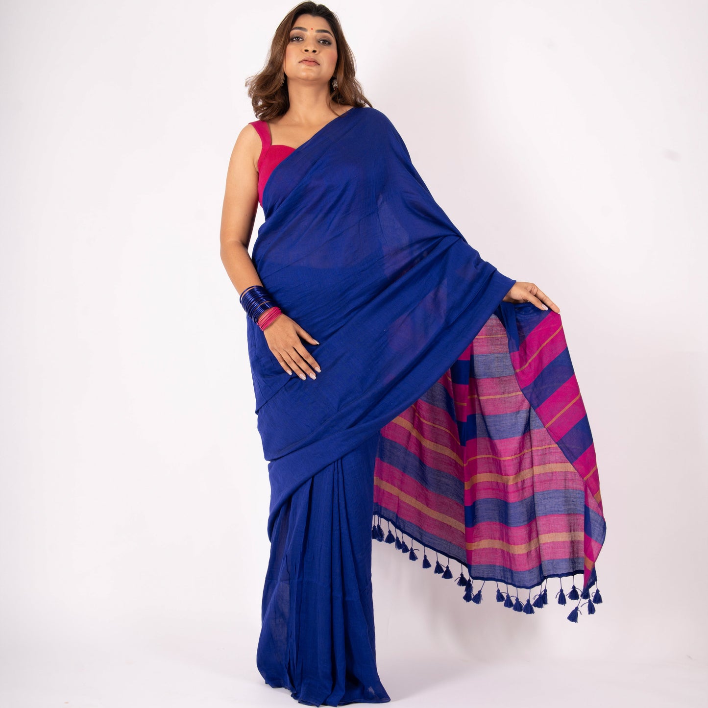 Woman wearing a blue saree with a pink and purple plaid pattern on a white background