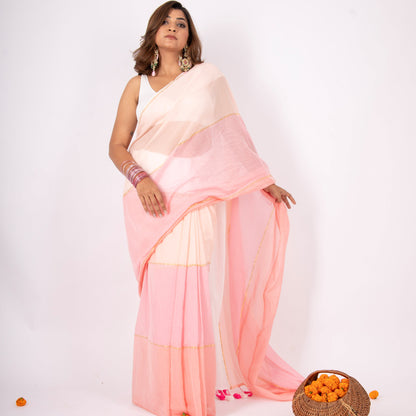 Woman wearing a light pink saree with a white blouse against a white background
