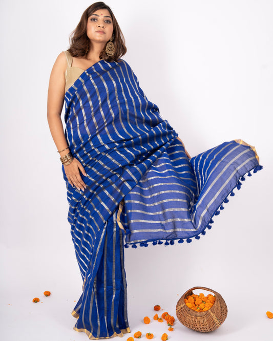 Woman wearing a blue saree with white stripes on a white background