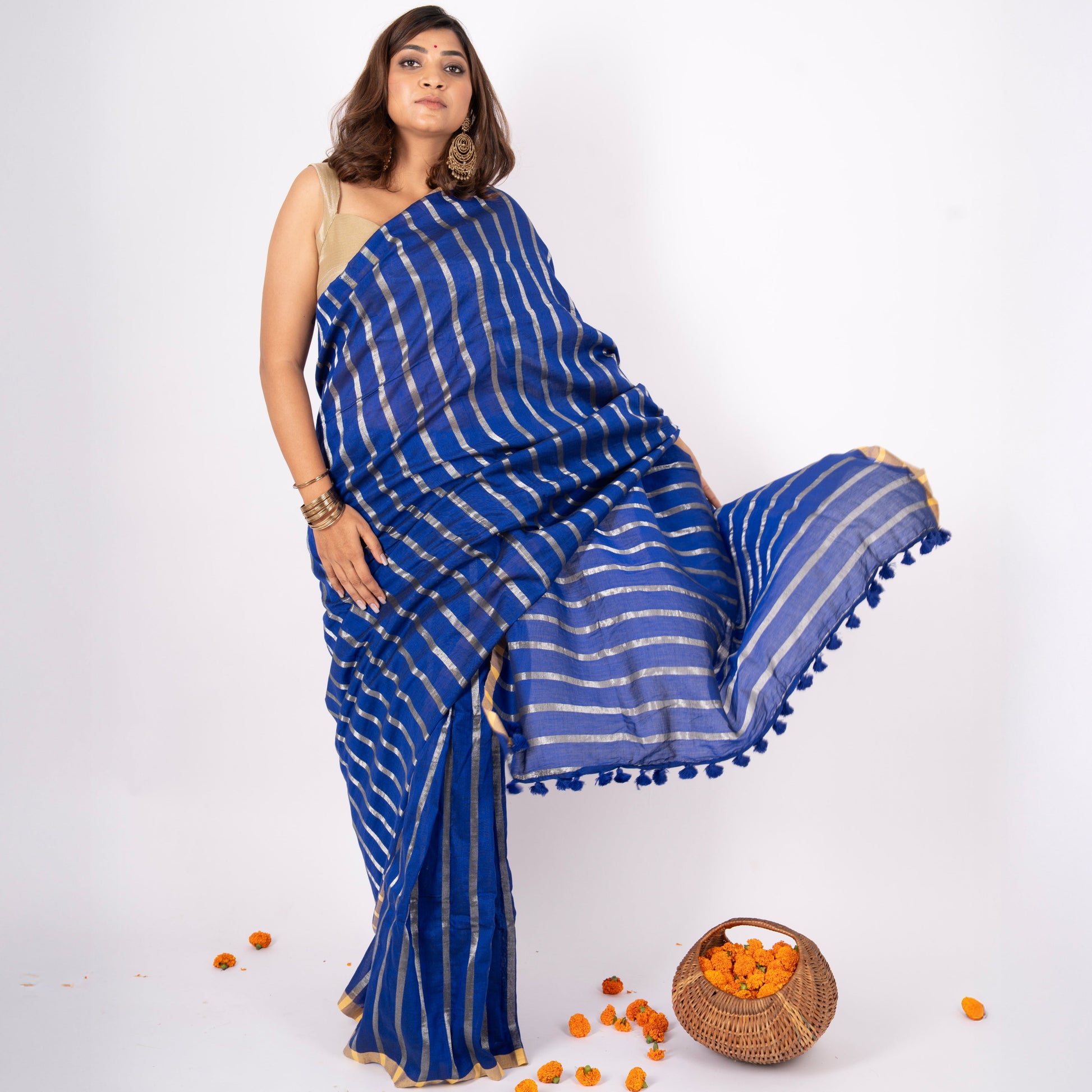 Woman wearing a blue saree with white stripes on a white background