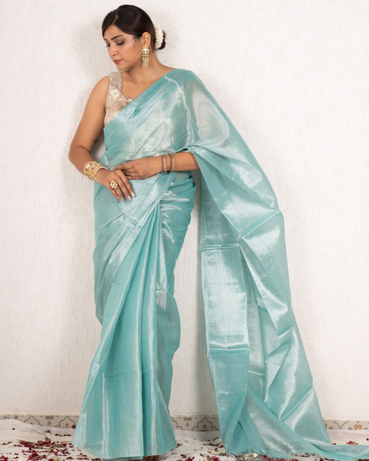 Woman wearing a light blue saree with a white background