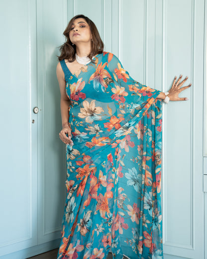 Woman wearing a floral dress against a light blue wall.